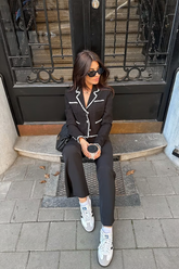 a lady wears a black tweed jacket with black pants